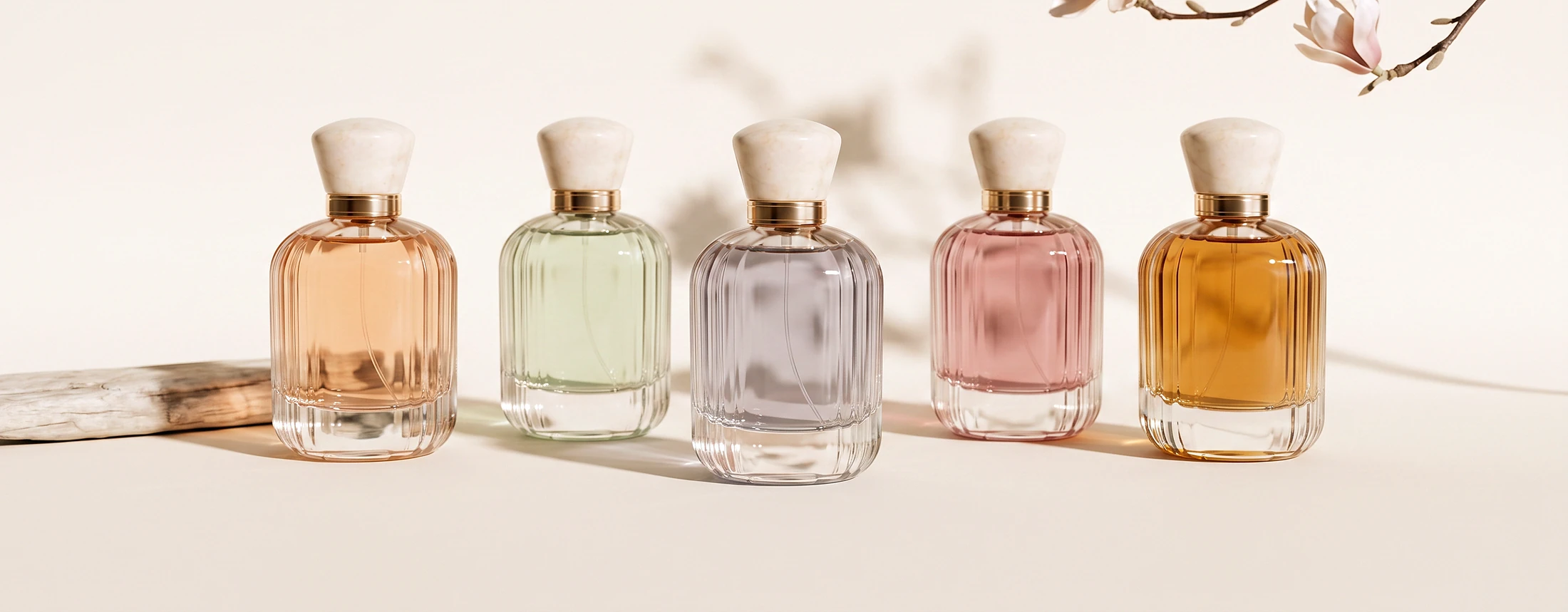 The five Solenne fragrances standing in a row beneath a magnolia branch.